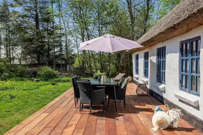a patio with a table and chairs and an umbrella at JB199-Fjerritslev-Svinklovvej-403 in Fjerritslev