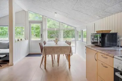 a kitchen with a table with chairs and a television at JB118-Fjerritslev-Ahornvej-8 in Fjerritslev