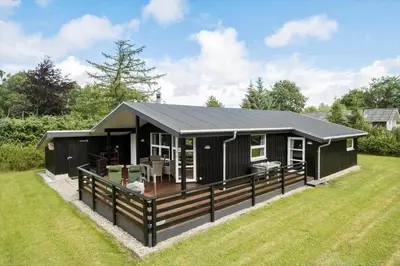 a black modular house with a deck on a yard at JB139-Fjerritslev-Kastanievej-13 in Fjerritslev