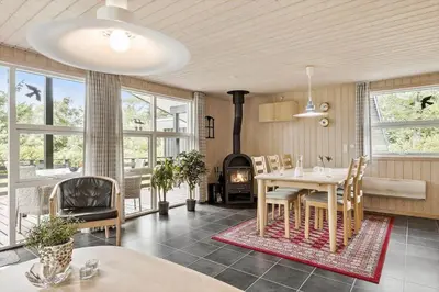 a dining room with a table and a fireplace at JB139-Fjerritslev-Kastanievej-13 in Fjerritslev