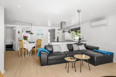 a living room with a black couch and a kitchen at JB128-Fjerritslev-Pilevej-2 in Fjerritslev