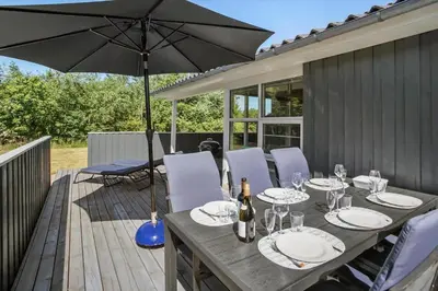 a wooden table with an umbrella on a deck at JB792-Fjerritslev-Egevej-34 in Fjerritslev