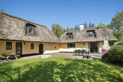 a large house with a thatched roof with a yard at JB186-Fjerritslev-Gyvelstien-27 in Fjerritslev