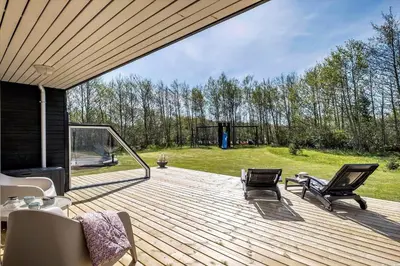 a wooden deck with two chairs and a gazebo at JB215-Brovst-Kronvildtvej-194 in Brovst