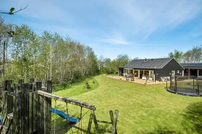 a backyard with a playground and a house at JB215-Brovst-Kronvildtvej-194 in Brovst