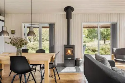 a dining room with a table and a fireplace at JB242-Fjerritslev-Poppelvej-8 in Fjerritslev