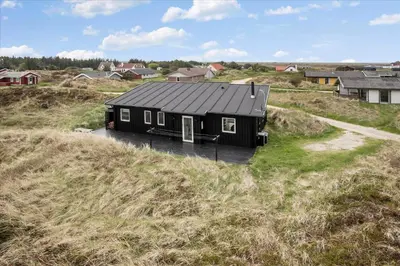 a black house sitting on top of a hill at JB140-Frostrup-Svenstibakkevej-68 in Frøstrup