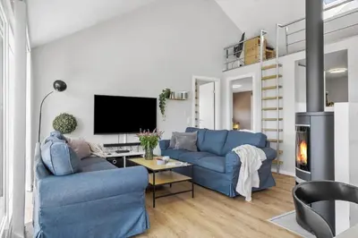 a living room with two blue couches and a tv at JB214-Brovst-Kronvildtvej-214 in Brovst