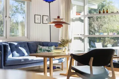 a living room with a blue couch and a table at JB219-Fjerritslev-Tyttebaerstien-4 in Fjerritslev