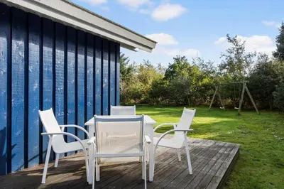 a patio with a table and chairs and a swing at JB219-Fjerritslev-Tyttebaerstien-4 in Fjerritslev