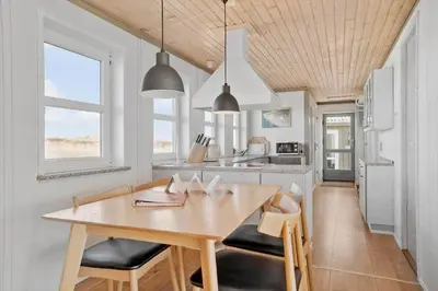 a kitchen with a wooden table and chairs at JB109-Frostrup-Strandkaervej-8 in Frøstrup