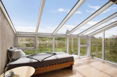 a bedroom with a bed in a room with windows at JB109-Frostrup-Strandkaervej-8 in Frøstrup
