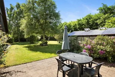 a table with an umbrella next to a garden at JB148-Fjerritslev-Svinklovvej-107 in Fjerritslev
