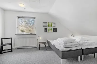 a white bedroom with a bed and a chair at JB148-Fjerritslev-Svinklovvej-107 in Fjerritslev