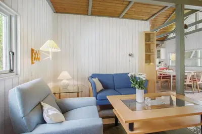 a living room with a blue couch and a table at JB329-Brovst-Egernvej-29 in Brovst