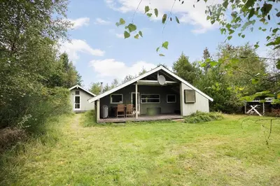 a small white house with a porch on a field at JB329-Brovst-Egernvej-29 in Brovst
