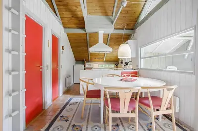 a kitchen with a table and chairs and a red door at JB329-Brovst-Egernvej-29 in Brovst