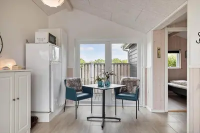 a kitchen with a table and chairs and a refrigerator at JB234-Frostrup-Strandvejen-83-A in Frøstrup