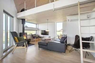 a living room with a couch and a loft bed at JB176-Brovst-Kronvildtvej-152 in Brovst