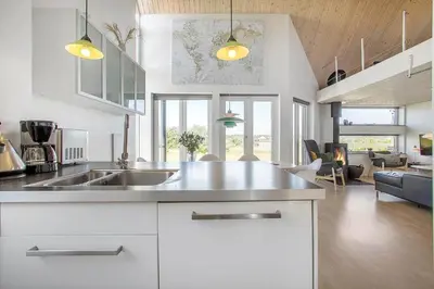 a kitchen with a sink and a living room at JB176-Brovst-Kronvildtvej-152 in Brovst