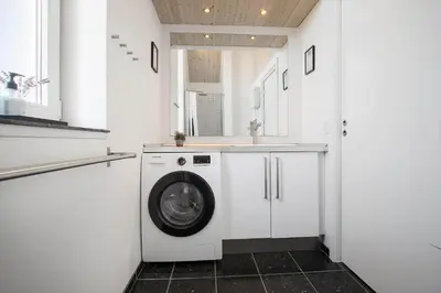 a washing machine in a white laundry room with a counter at JB176-Brovst-Kronvildtvej-152 in Brovst