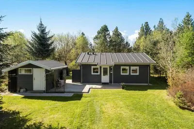 a small black house in the middle of a yard at JB246-Brovst-Graevlingevej-13 in Brovst