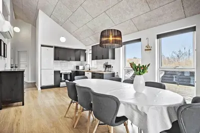 a kitchen and dining room with a white table and chairs at JB876-Brovst-Kronvildtvej-40 in Brovst