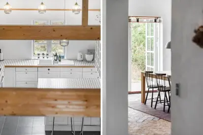 a kitchen and dining room with white cabinets and a table at JB175-23-Brovst-Kronvildtvej-60 in Brovst