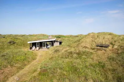 a small house on top of a grassy hill at JB119-Brovst-Ejstrup-Strandvej-18 in Brovst