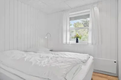 a white bedroom with a bed and a window at JB318-Fjerritslev-Fiskerstien-10 in Fjerritslev