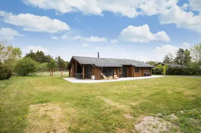 a log cabin in a field with a playground at JB125-Fjerritslev-Lyngbjergvej-31 in Fjerritslev