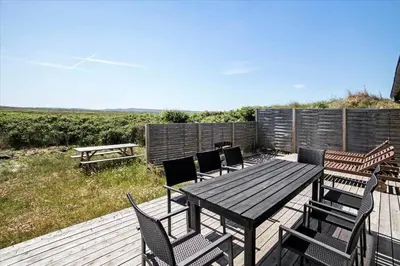 a wooden deck with a table and chairs and a bench at JB171-Brovst-Ejstrup-Strandvej-28 in Brovst