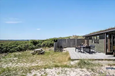 a cabin with a table and a picnic table on a deck at JB171-Brovst-Ejstrup-Strandvej-28 in Brovst