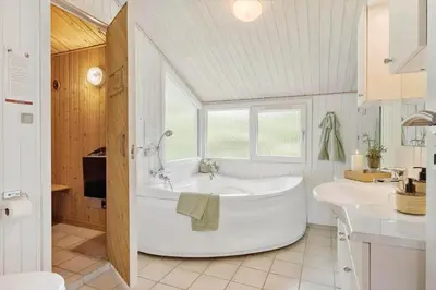 a white bathroom with a tub and a sink at JB716-Fjerritslev-Tyttebaerstien-16 in Fjerritslev