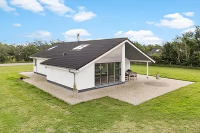 a house with a pitched roof with a patio at JB239-Brovst-Kronvildtvej-208 in Brovst