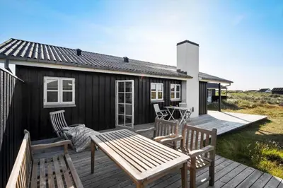 a wooden deck with a bench and a house at JB144-Frostrup-Horsbakkevej-7 in Frøstrup
