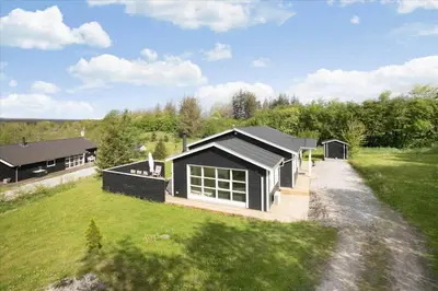 a black house on a green field with a house at JB666-Fjerritslev-Aspevej-21 in Fjerritslev