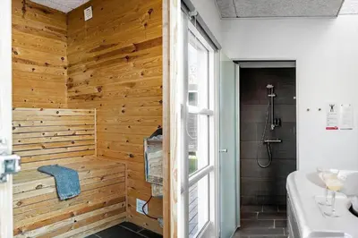 a bathroom with a wooden wall and a shower at JB666-Fjerritslev-Aspevej-21 in Fjerritslev