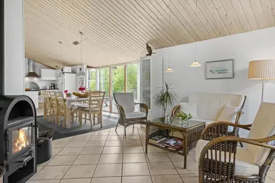 a living room with a fireplace and a table and chairs at JB828-Fjerritslev-Revlingestien-71 in Fjerritslev