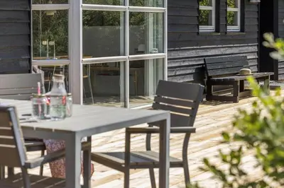a table and chairs on a wooden deck with a patio at JB696-Fjerritslev-Blabaerstien-56 in Fjerritslev