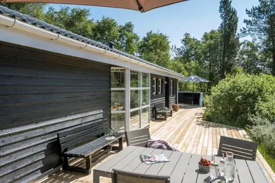 a wooden deck with a bench and a table at JB696-Fjerritslev-Blabaerstien-56 in Fjerritslev