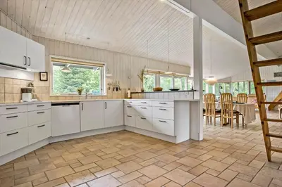 a kitchen with white cabinets and a table and chairs at JB182-Fjerritslev-Gyvelstien-39 in Fjerritslev
