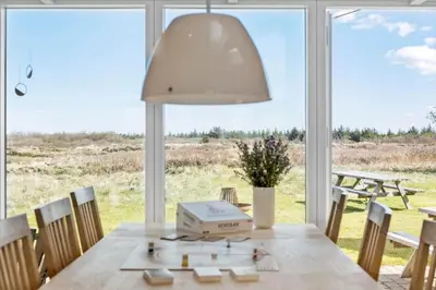 a dining room with a table and a large window at JB203-Brovst-Kronvildtvej-35 in Brovst