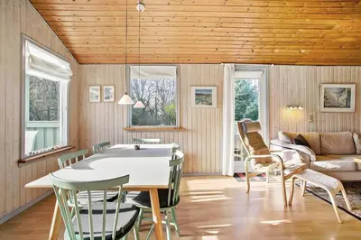 a living room with a table and chairs at JB122-Fjerritslev-Tyttebaerstien-14 in Fjerritslev