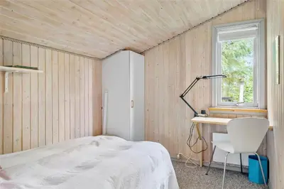 a bedroom with a bed and a desk and a chair at JB122-Fjerritslev-Tyttebaerstien-14 in Fjerritslev