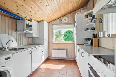 a small kitchen with white appliances and a window at JB122-Fjerritslev-Tyttebaerstien-14 in Fjerritslev