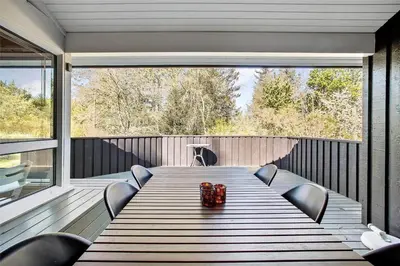 a large wooden table on a deck with chairs at JB154-Fjerritslev-Bredvandet-34 in Fjerritslev
