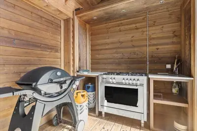 a kitchen with a stove in a wooden wall at JB177-Fjerritslev-Aspevej-44 in Fjerritslev