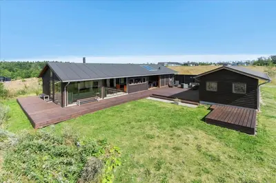 a house with a deck and a large yard at JB177-Fjerritslev-Aspevej-44 in Fjerritslev