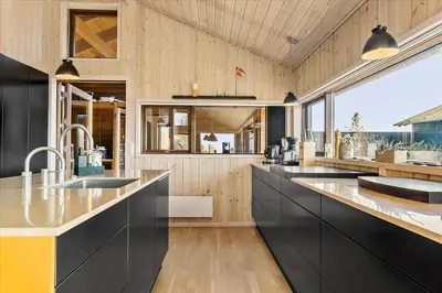a large kitchen with black cabinets and a large window at JB177-Fjerritslev-Aspevej-44 in Fjerritslev